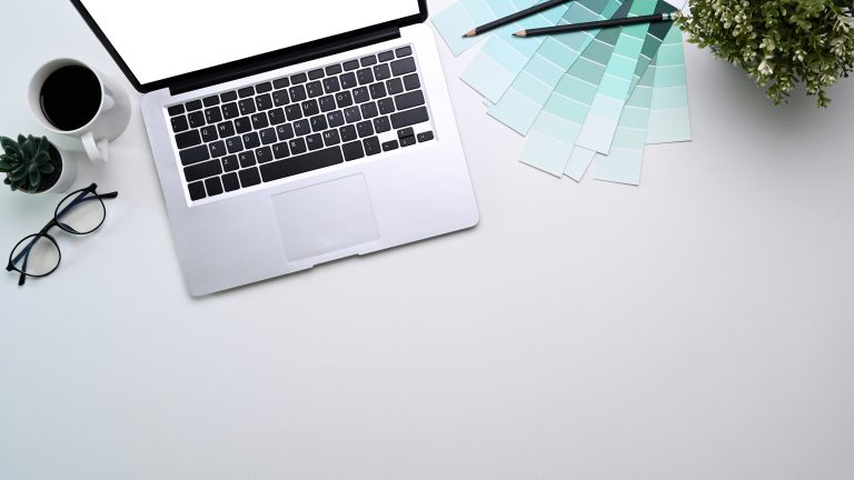 Minimal web design workspace with laptop, colour swatches, and copy space