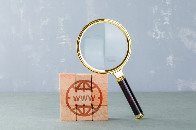 Magnifying glass and internet blocks representing a domain name search