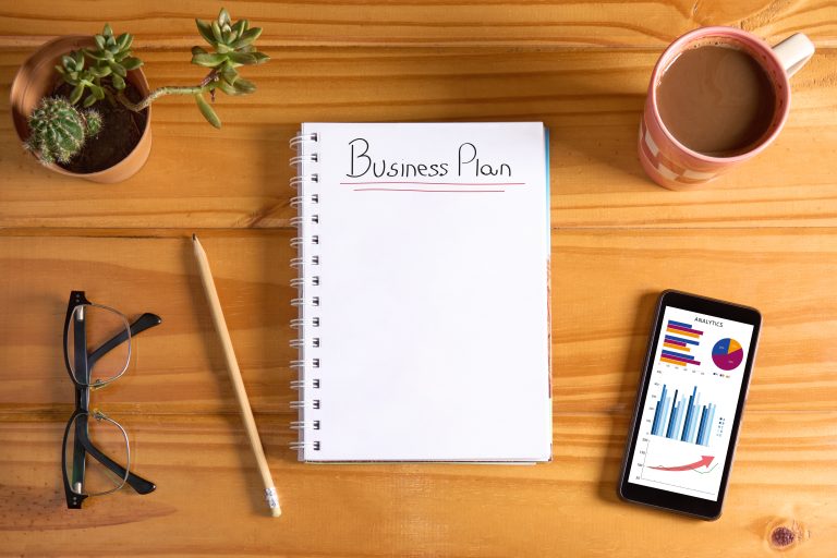 Notebook labelled business plan on a desk