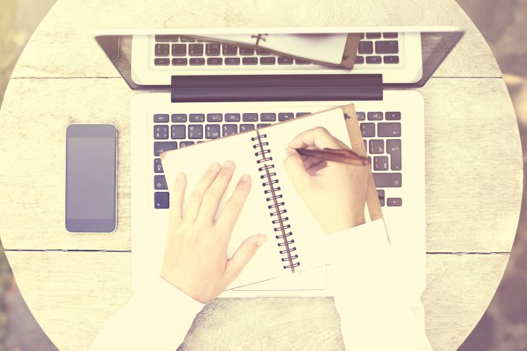 Writing notes in a notebook for website copywriting