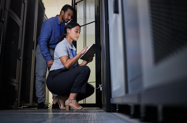 Engineers working in a server room with networking equipment