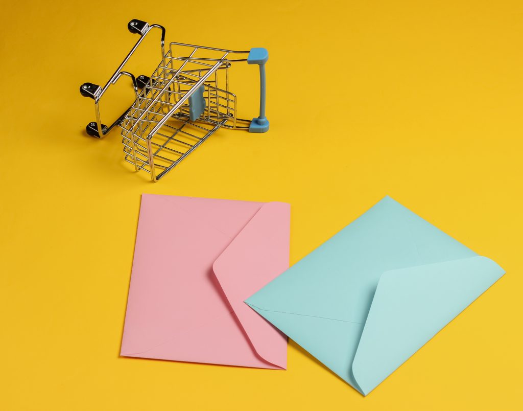 Envelopes and shopping trolley representing ecommerce email campaigns
