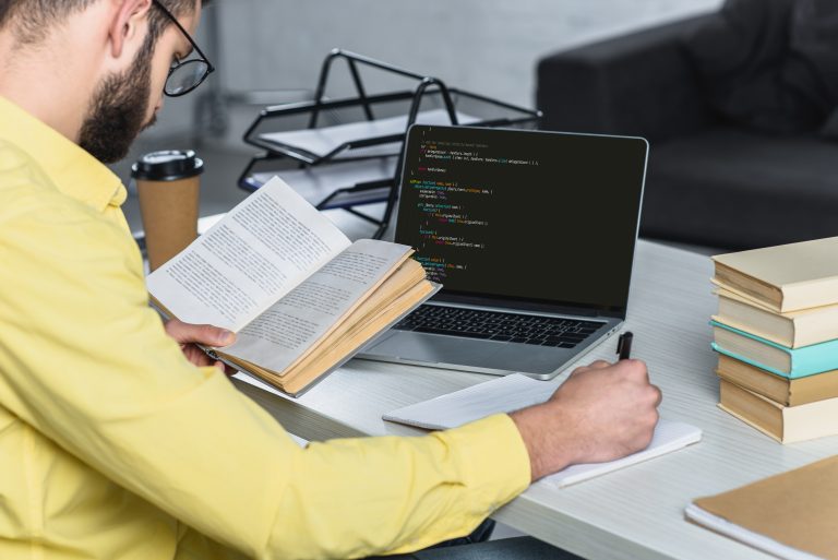 Person studying web development with a laptop showing code