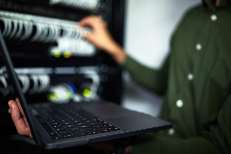 Technician using a laptop in a server room