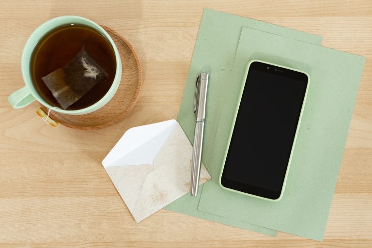 Envelope, phone and notepad on a wooden table
