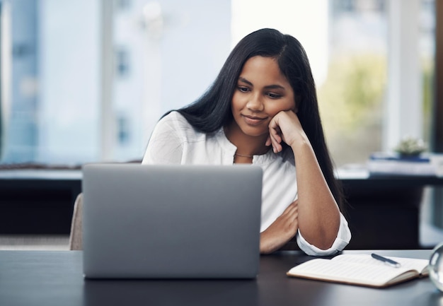 Writer editing an existing blog post with notes and a laptop