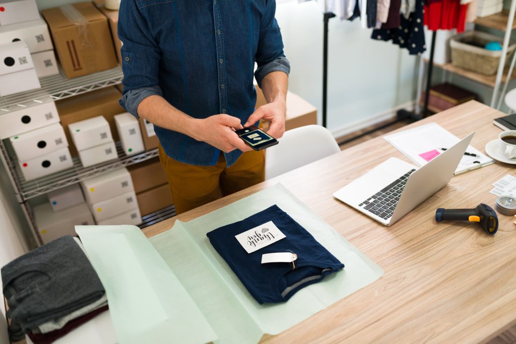 Small business owner photographing a thank you note on a customer package