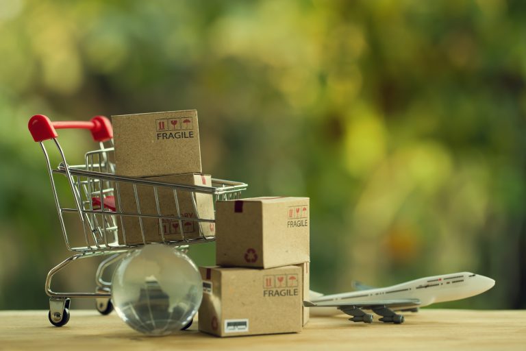 Shopping cart with parcels, globe and plane for international ecommerce