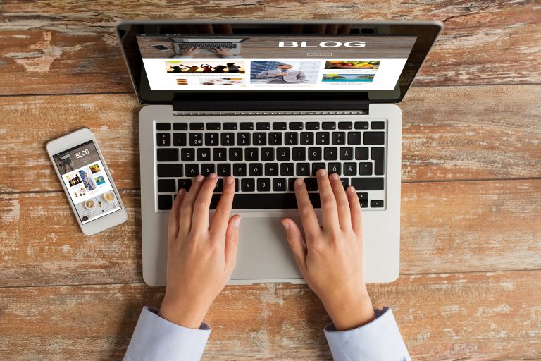 Laptop and smartphone displaying blog and social media content