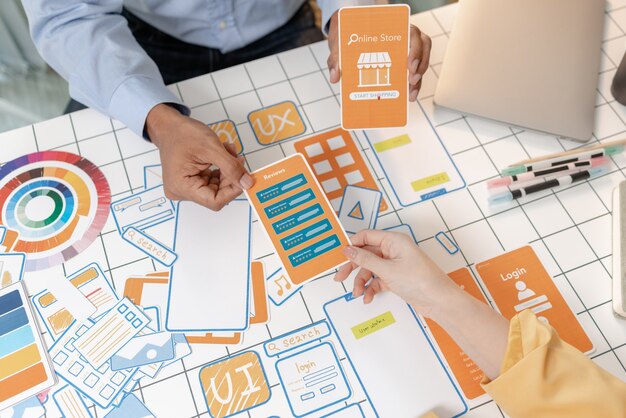 UX designers collaborating with website wireframes and interface cards