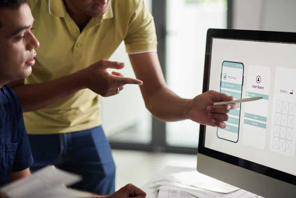 Designers discussing a website screen layout for usability