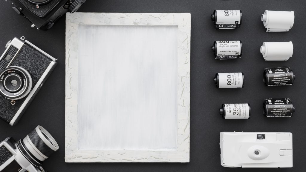 Cameras and film arranged beside a photo frame