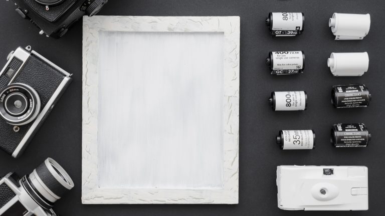 Cameras and film arranged beside a photo frame