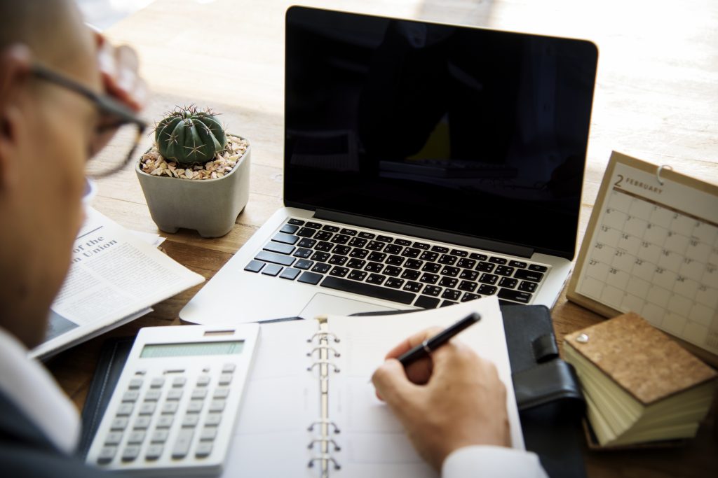 Person calculating website project costs at a desk