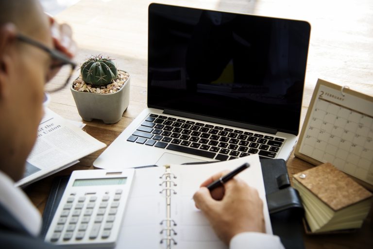 Person calculating website project costs at a desk
