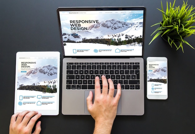 Hands using responsive website layouts across several devices