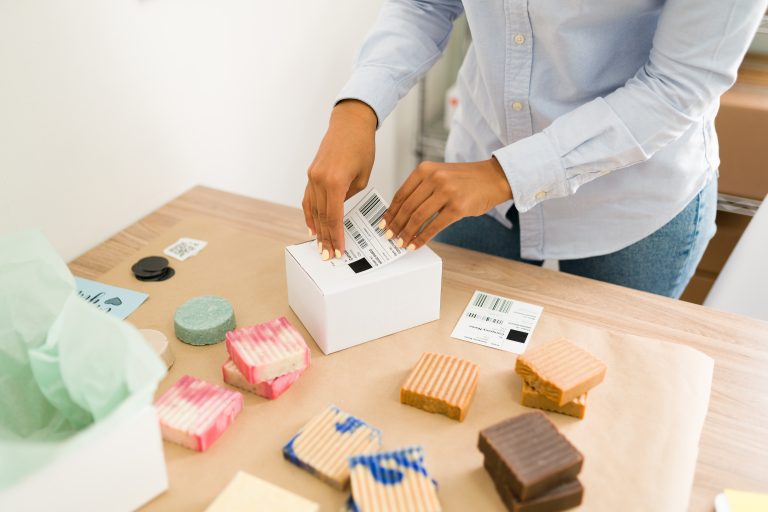 Hands labelling a package for an online customer order