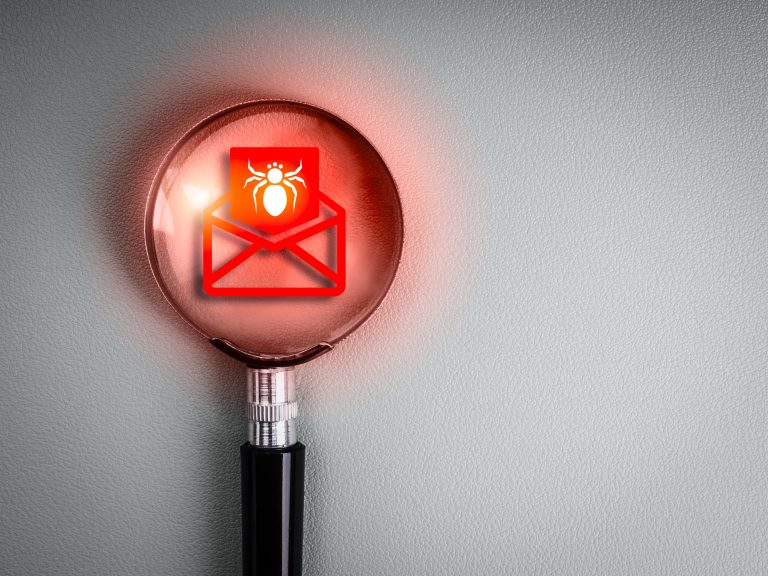 Warning symbol on an email envelope under a magnifying glass