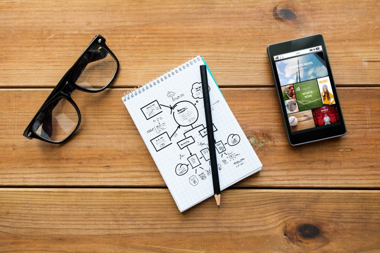 Notebook and smartphone used for planning social media content